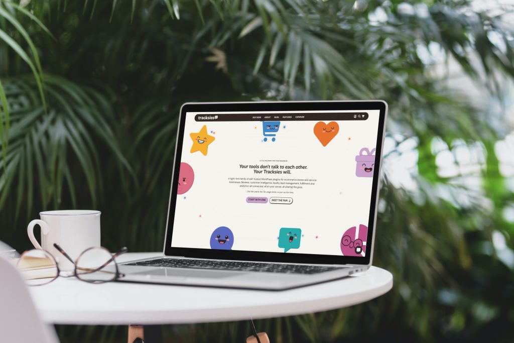 Laptop displaying Tracksies WordPress plugin website with colourful characters
